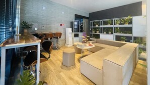 A modern interior with a bar area, seating, and a plant wall. - Browndot Hotel (Yangsan)