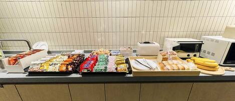 A buffet counter with various food items and kitchen appliances.