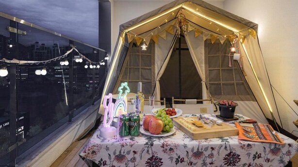 A tent set up inside a room with a table in front, containing food and drinks. - Browndot Hotel (Yangsan)