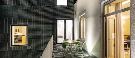 Un interior moderno con una escalera que conduce a un comedor, que cuenta con una mesa, sillas y vistas de la habitación contigua.