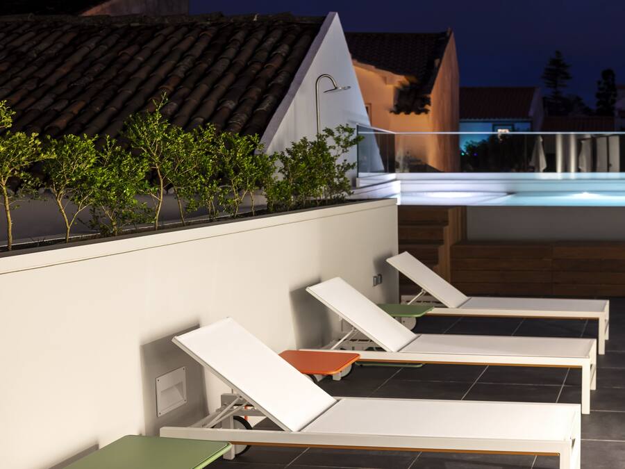 A rooftop lounge area with sunbeds and a hot tub.