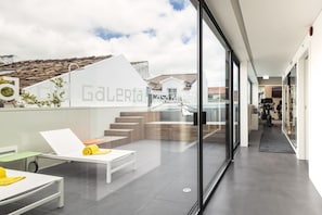 Ein modernes Hotelzimmer mit Balkon, Essbereich und Blick auf die Stadt.