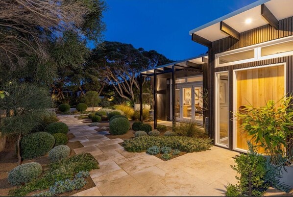 Stunning two-story residence with a serene garden setting and entrance.