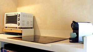 Una cocina con microondas, cafetera y tostadora sobre una encimera.