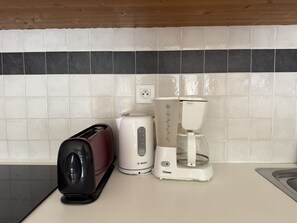 Eine Küche mit Toaster, Kaffeemaschine und Mixer auf der Arbeitsfläche.