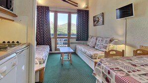 Ein gemütliches Zimmer mit Küchenzeile, einer Couch, einem Tisch und einem Bett.