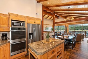 A kitchen with stainless steel appliances, wooden cabinets, and a granite countertop.