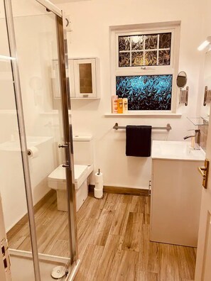 Huis | Badkamer | Een bad/douchecombinatie, een diep bad, een haardroger, handdoeken