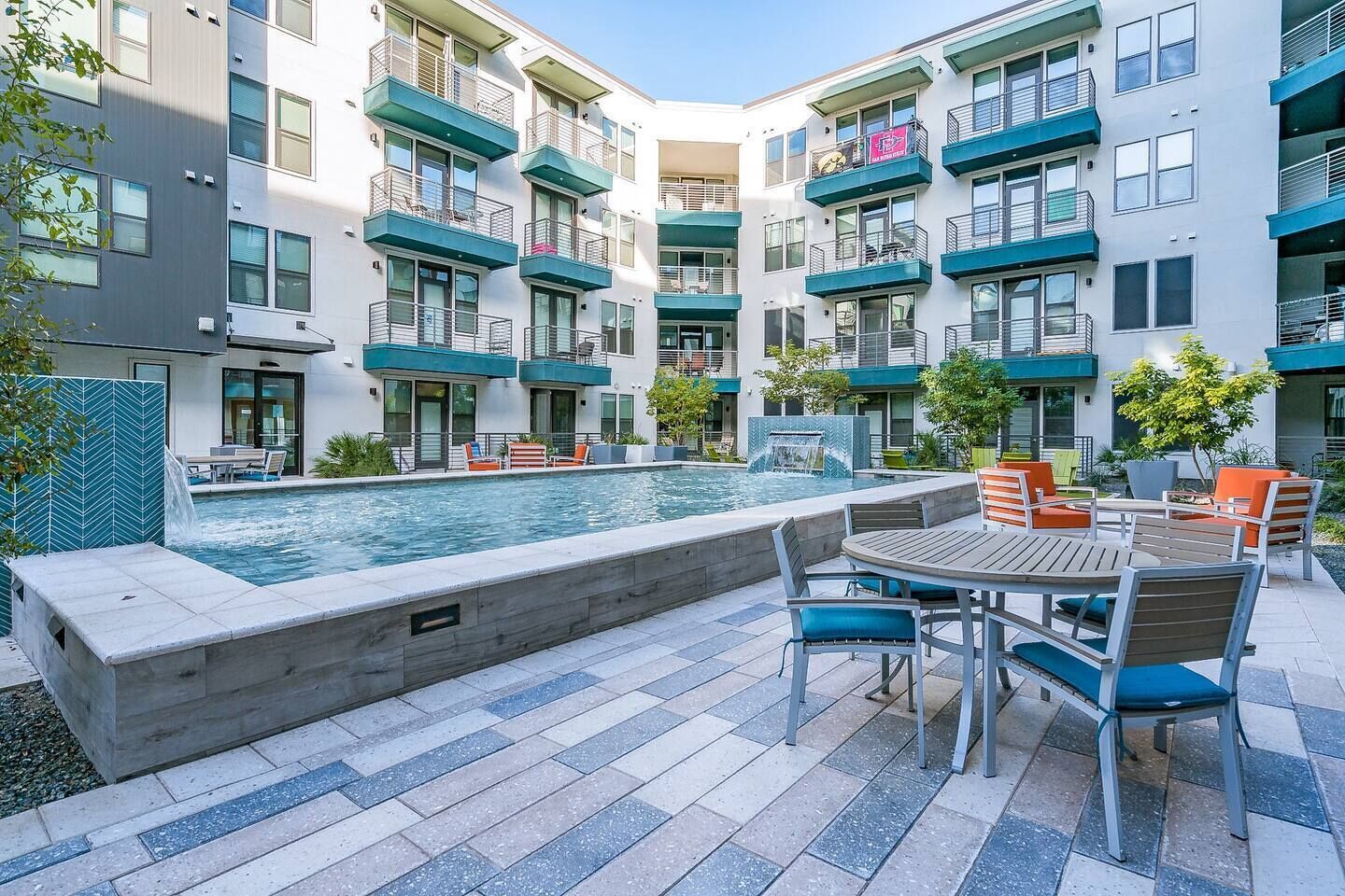 A modern building with a pool and outdoor seating area.