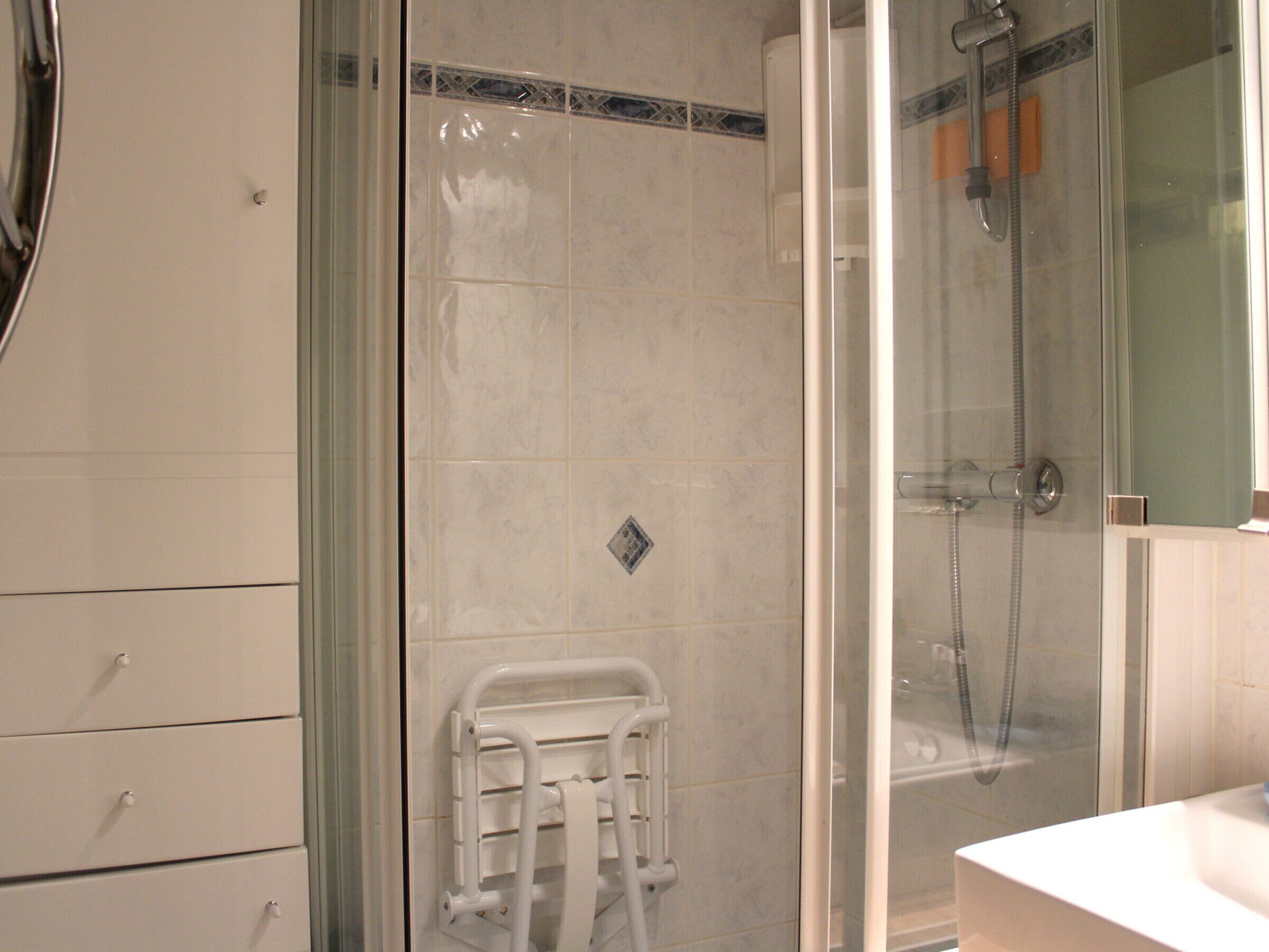 Ein Duschbereich mit Glasdusche und einer weißen Handtuchstange.