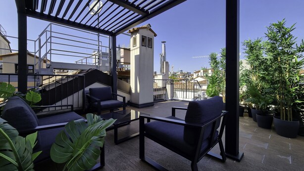 A rooftop terrace with outdoor seating, a staircase, and potted plants. - Italianway - Corso Venezia 7 (Milan)