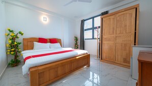 Un dormitorio con cama de madera, ventilador de techo, armario y ventana con cortinas.