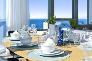 Dine with a serene ocean view from this room's expansive window.