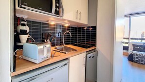 A compact kitchen with a microwave, toaster, sink, and dishwasher. - Renovated Studio 3 pers. - Ski-in Ski-out with Balcony (Les Menuires)