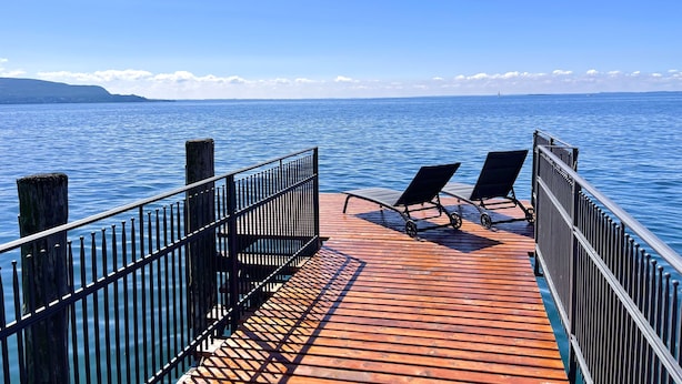 A wooden pier with metal railings and two empty lounge chairs facing a calm sea. - Lakefront villa with secular park, private jetty and pool 10 km from Salò (Toscolano Maderno)
