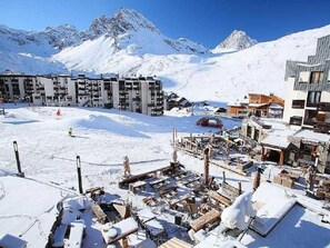 A snow-covered ski resort with modern buildings, a ski lift, and a mountain backdrop. - Prime Location (Tignes)