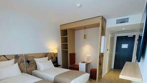 A hotel room with two beds, a desk, a chair, a wooden stool, and a bucket. - Courrier Sud (Quint-Fonsegrives)
