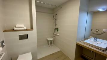 Un baño moderno con inodoro, ducha y lavamanos.