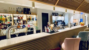 A bar area with a counter, multiple taps, and a variety of bottles and glasses. - Courrier Sud (Quint-Fonsegrives)