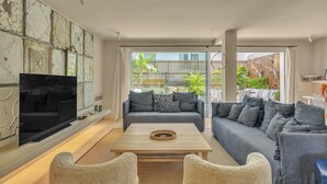 A modern living room with a sofa set, a coffee table, and a flat-screen TV. - Casa Bambu - Marbellamar (Marbella)