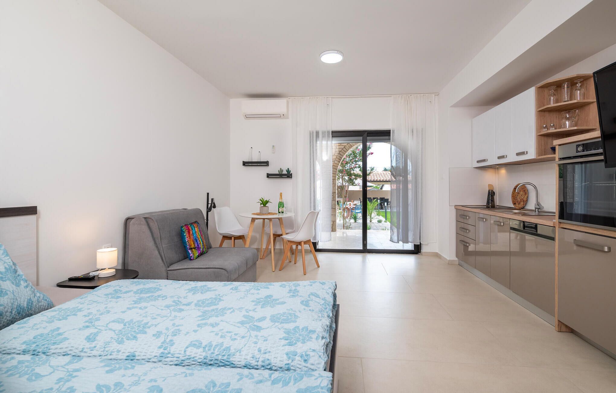 Une chambre d’hôtel moderne comprenant un lit, un canapé, un coin repas et une cuisine.