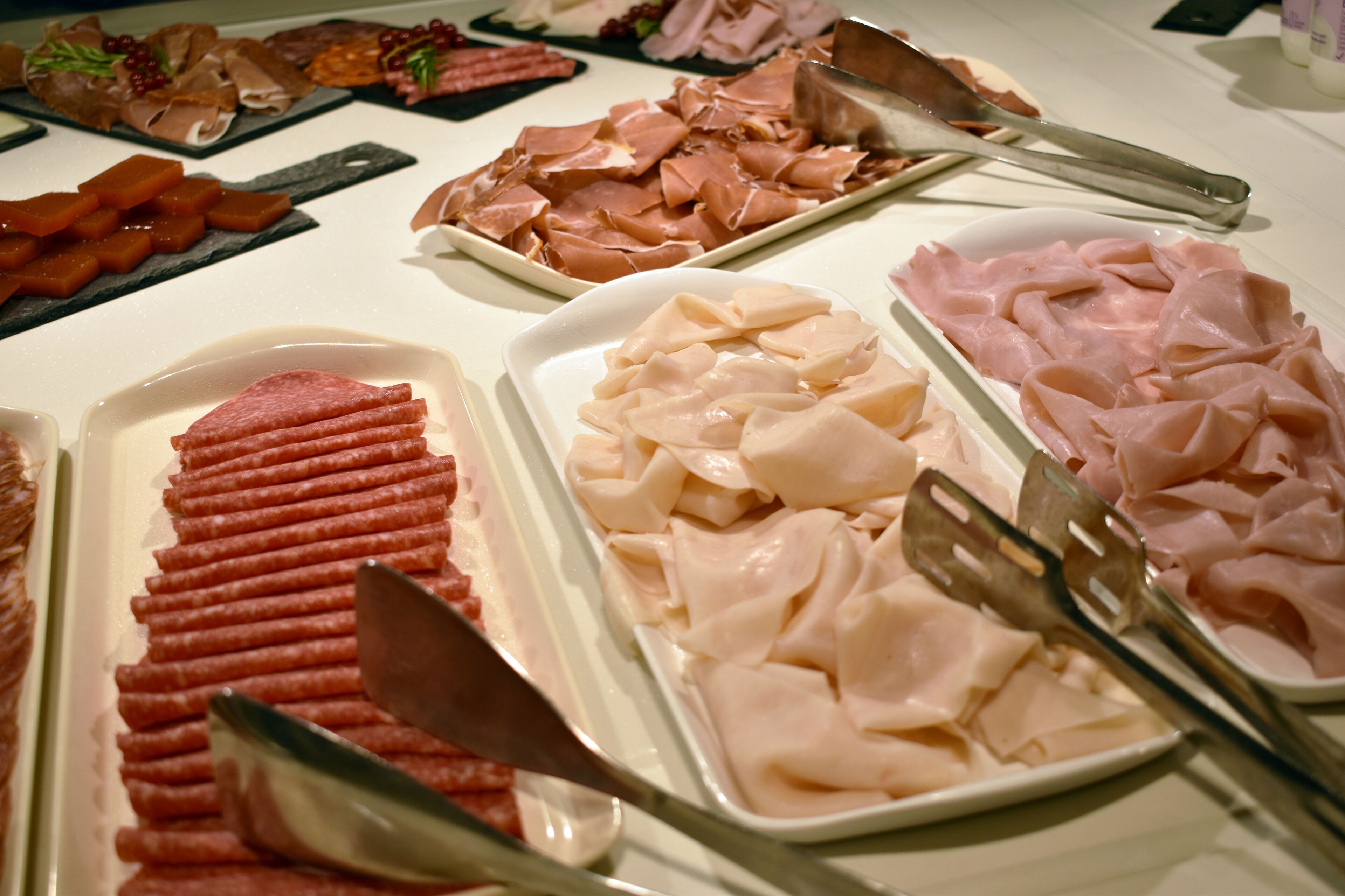 A buffet with various types of meat arranged on platters.