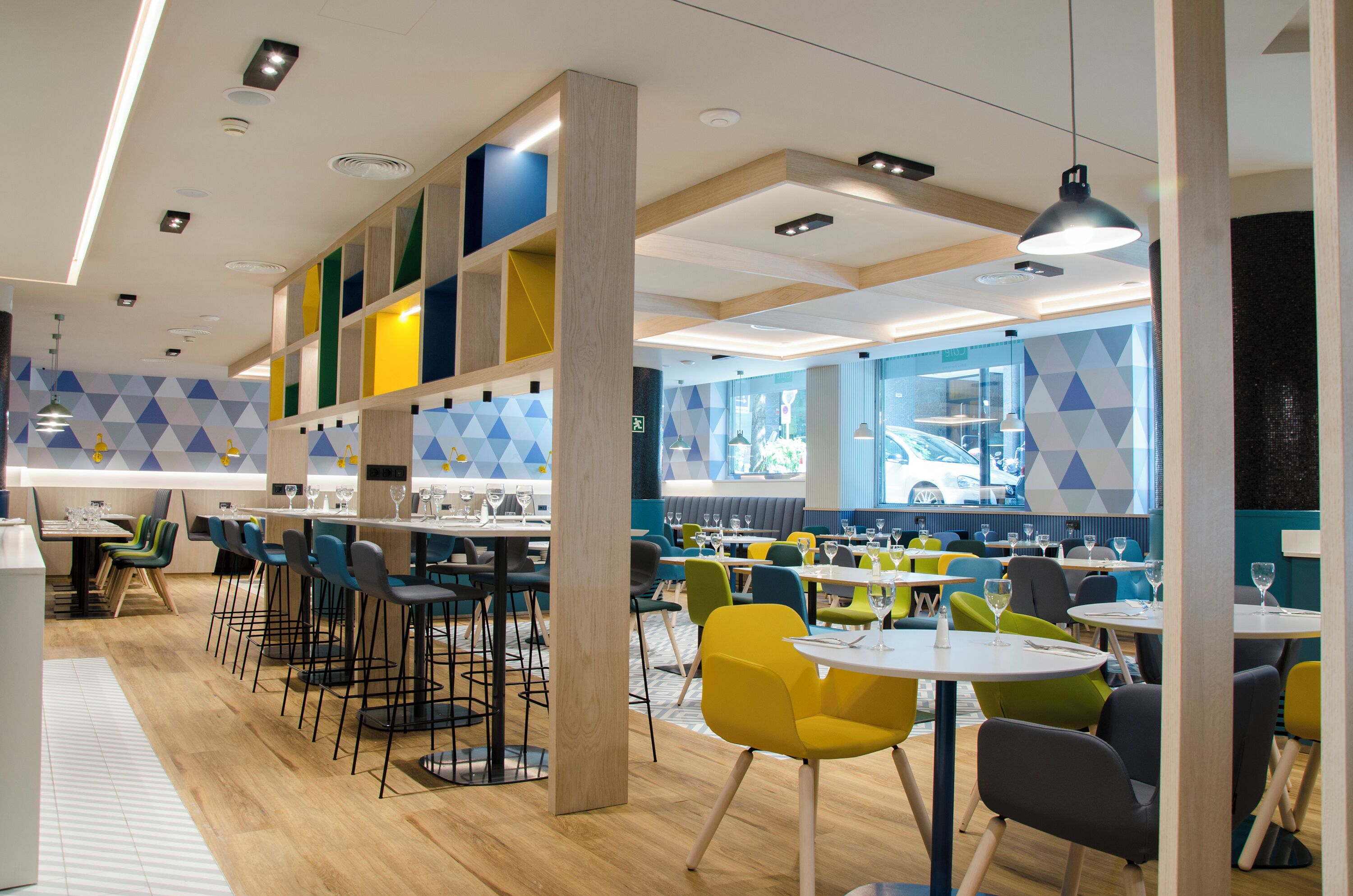 Un restaurante moderno con diversas opciones de asientos, como taburetes de bar y mesas redondas.