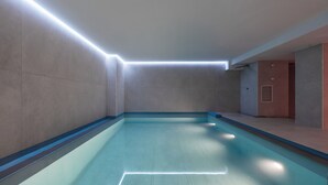 Une piscine dont le plafond et les murs sont ornés d’un motif lumineux géométrique.