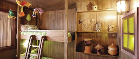 A rustic wooden room with a bunk bed, a ladder, and shelves with various items including a lantern, a drum, and a basket.