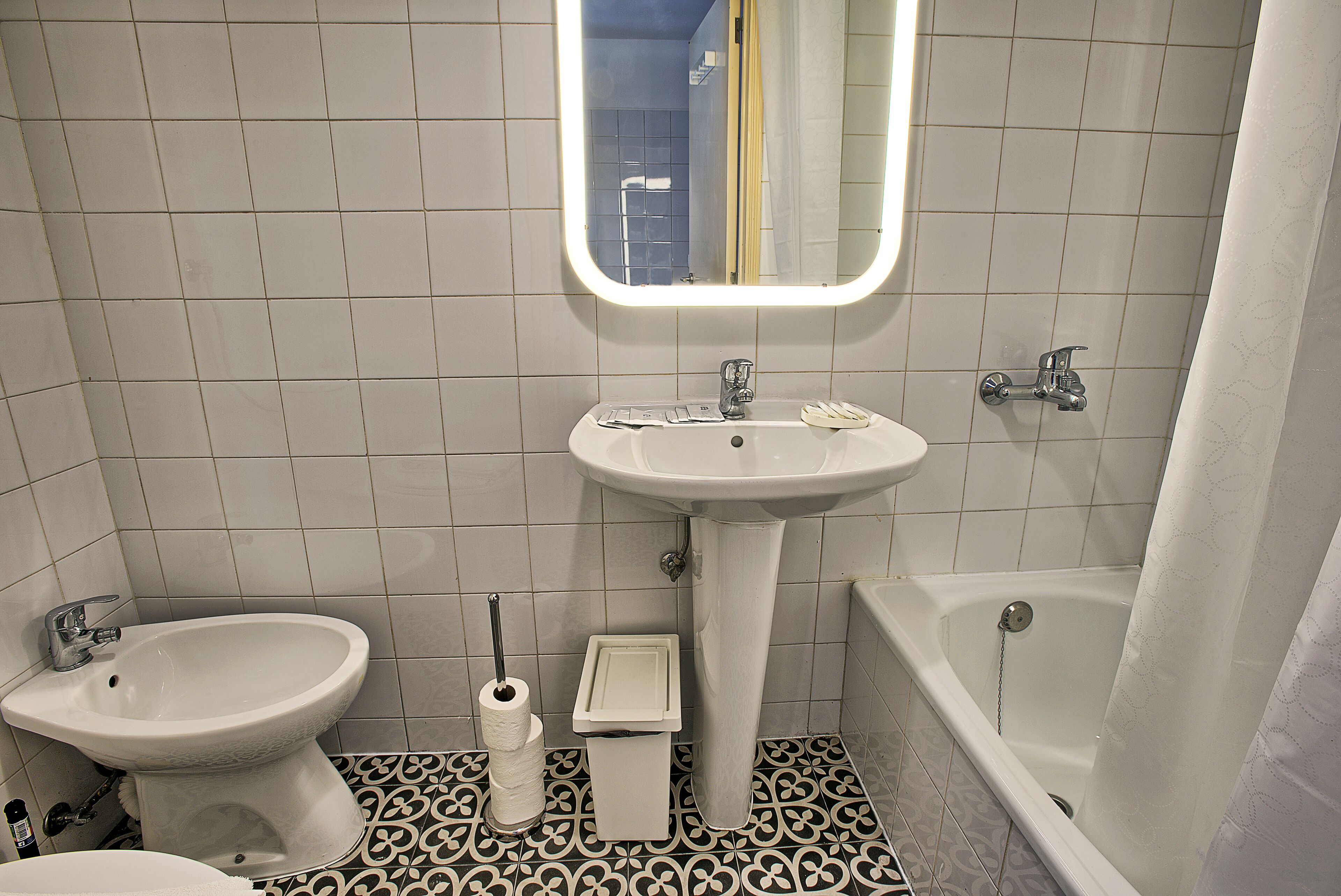 Ein Badezimmer mit einem Standwaschbecken, einem Bidet, einer Toilette und einer Badewanne.