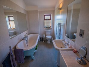 A bathroom with a bathtub, toilet, and sink. - The Steading (South Walls)