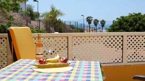 A table with a checkered tablecloth, a bottle, and fruits. - Apartment mit Meerblick in Optimaler Lage (Costa Adeje)