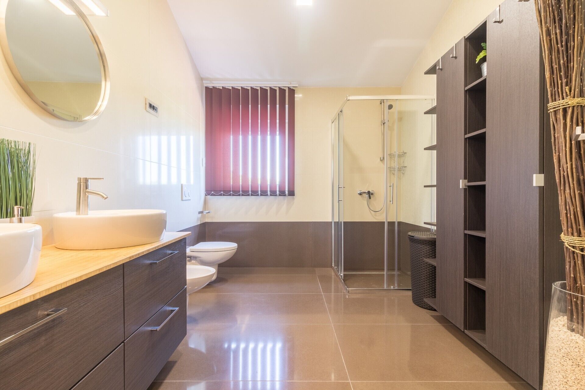 A modern bathroom with a large mirror, a sink, a toilet, and a shower area.