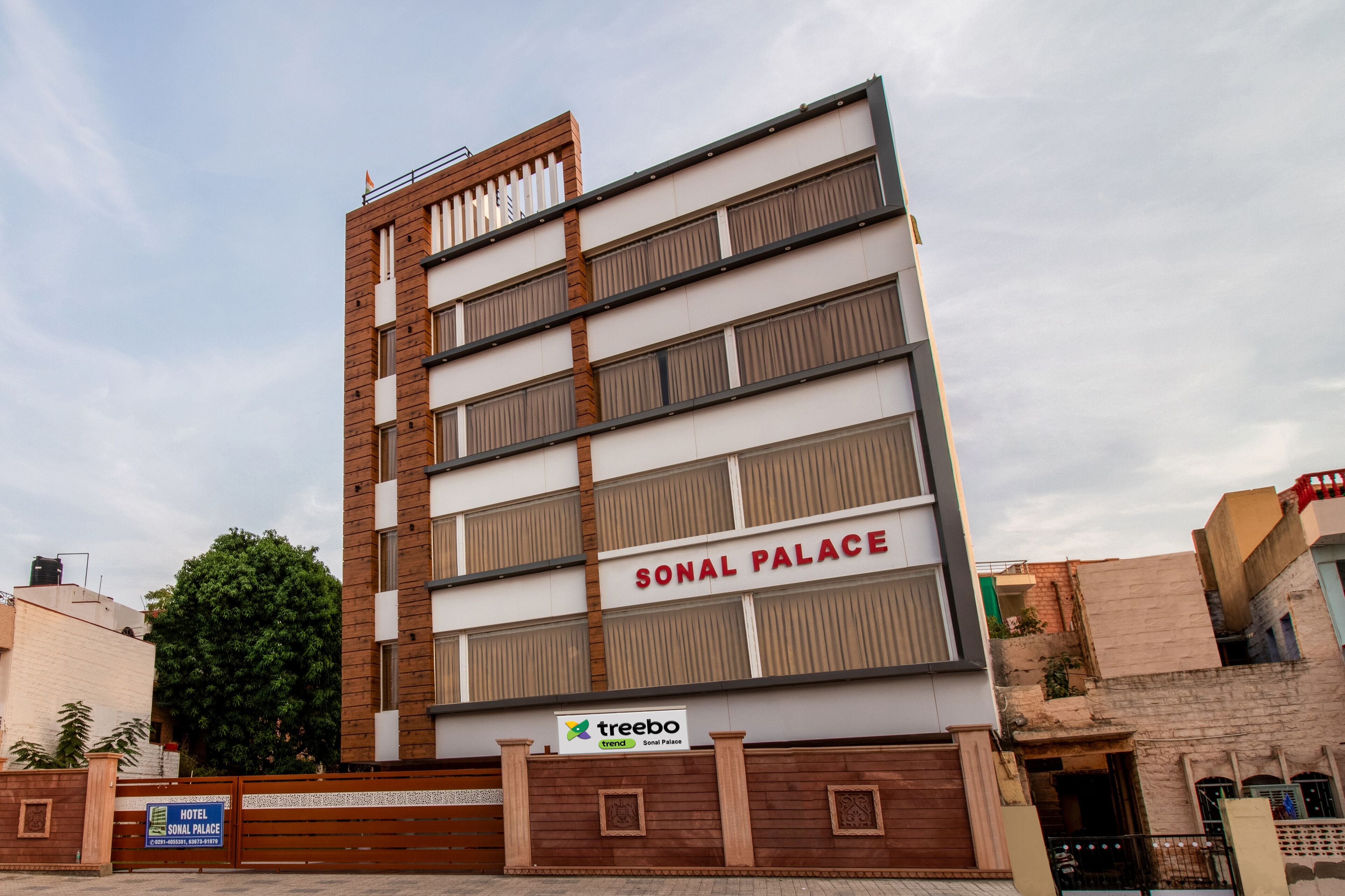 A multi-story hotel named Sonal Palace with a modern design, featuring a prominent sign and a logo for Treebo.