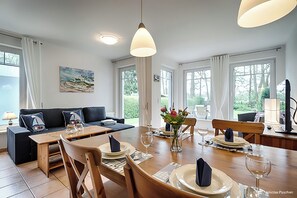 Relax in this stylish living room with a dining area, perfect for meals with friends and family.