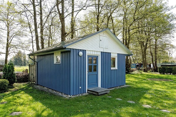 Situated in a serene natural setting, this charming building features a front door and a small window.