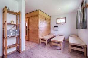 Simple, modern space with two beds, a shelf unit, and a window offering a view.