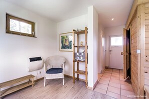 Enjoy a spacious room with a high ceiling, a window, and a wicker chair.
