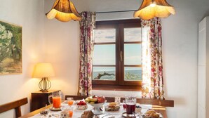 Una tavola imbandita per la colazione con diversi cibi e bevande, una lampada e un quadro appeso al muro.