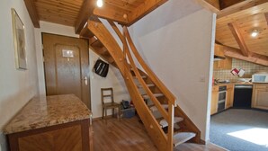A kitchen with wooden cabinets, a microwave, and a sink. - Apartment Alpina (Zermatt)