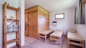 A wooden room with two single beds, a shelf with kitchen appliances, and a wooden door leading to another room. - Apartment for up to 4 people,central,quiet,south-facing terrace,sauna,WLAN,bicycle shed,parking lot (Prerow)