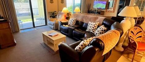 A living room with a sofa, a coffee table, a TV, and a chair.