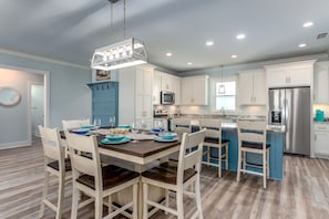 Enjoy cooking in this well-equipped kitchen with a central island, stainless steel appliances, and a dining area.