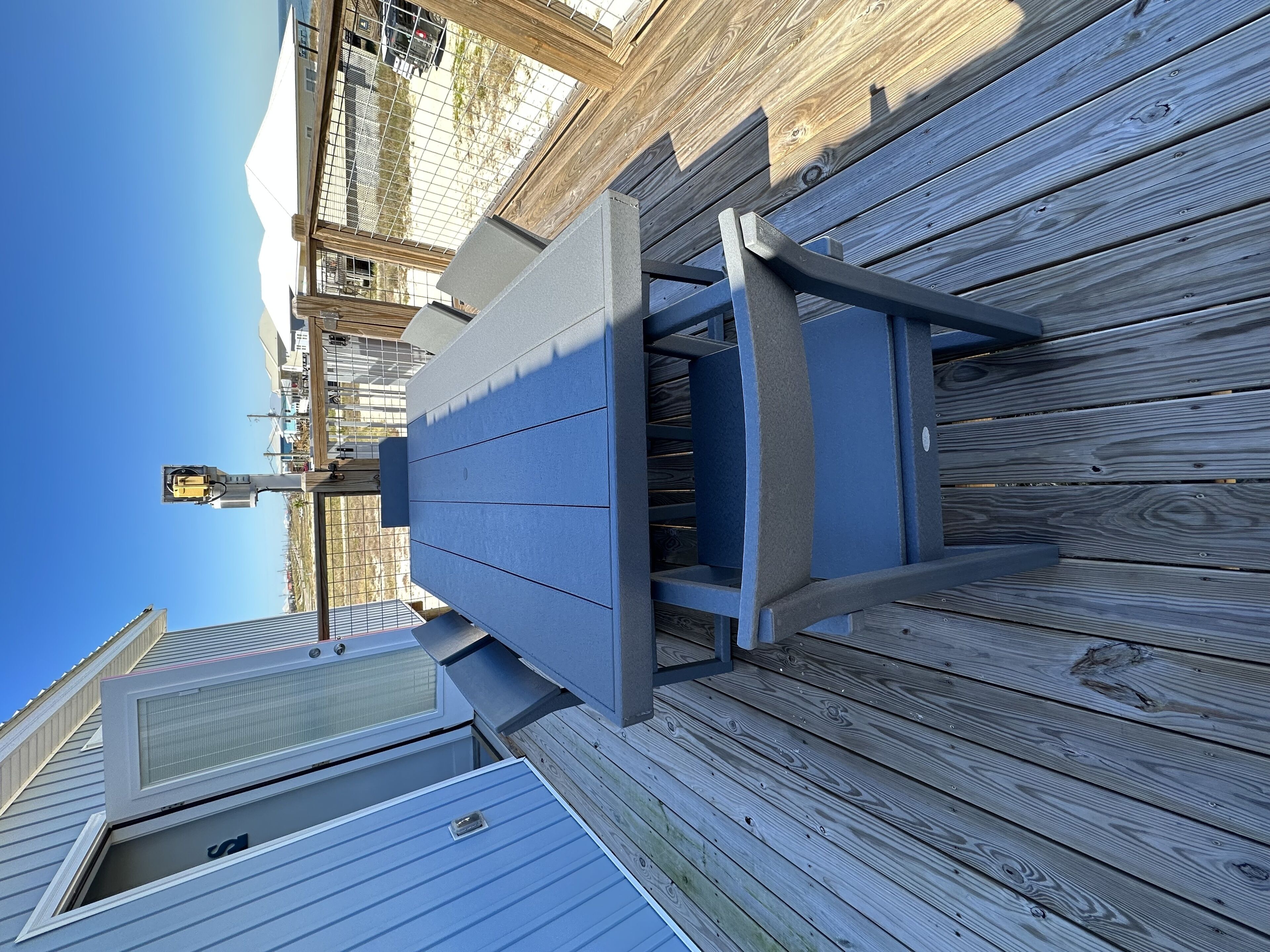 A deck with a metal railing and a window overlooking a building.