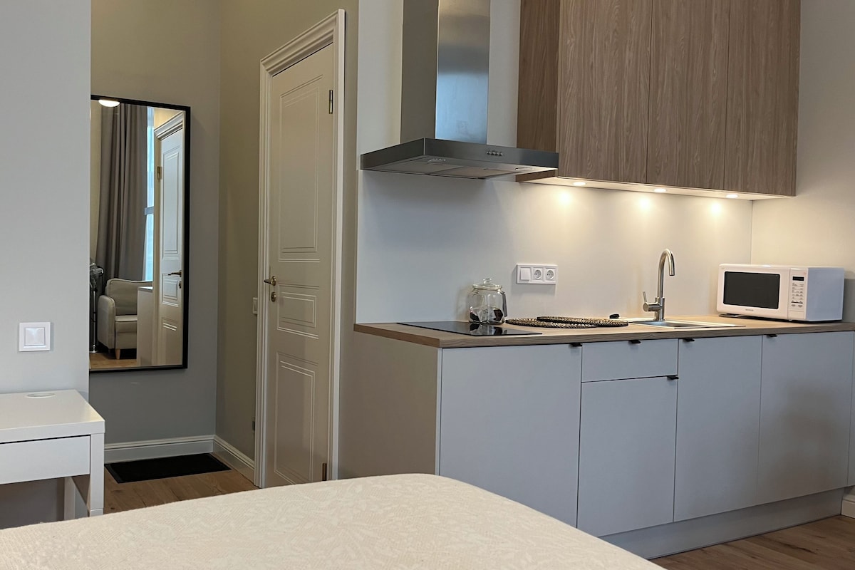 A compact kitchenette with a microwave, a small sink, and a cabinet.