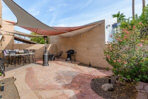 Enjoy al fresco dining and relaxation under the shade sail, with a grill and comfortable seating.