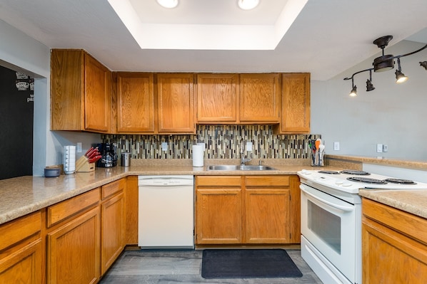 Enjoy cooking in this well-equipped kitchen with a central island, dishwasher, stove, and sink.