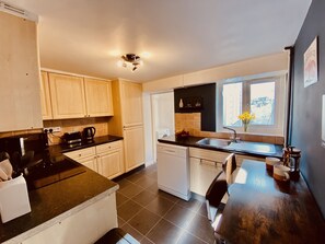 Enjoy cooking in this well-equipped kitchen with a dishwasher, stove, and sink.