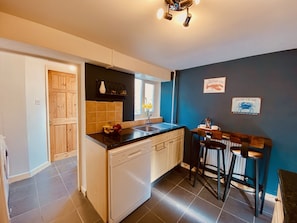 Enjoy cooking in this well-equipped kitchen with a central island, dishwasher, and bar area.