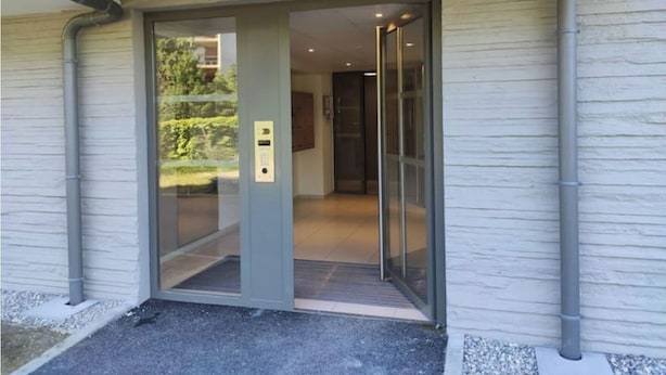 A modern building entrance with a glass door and a metal frame.